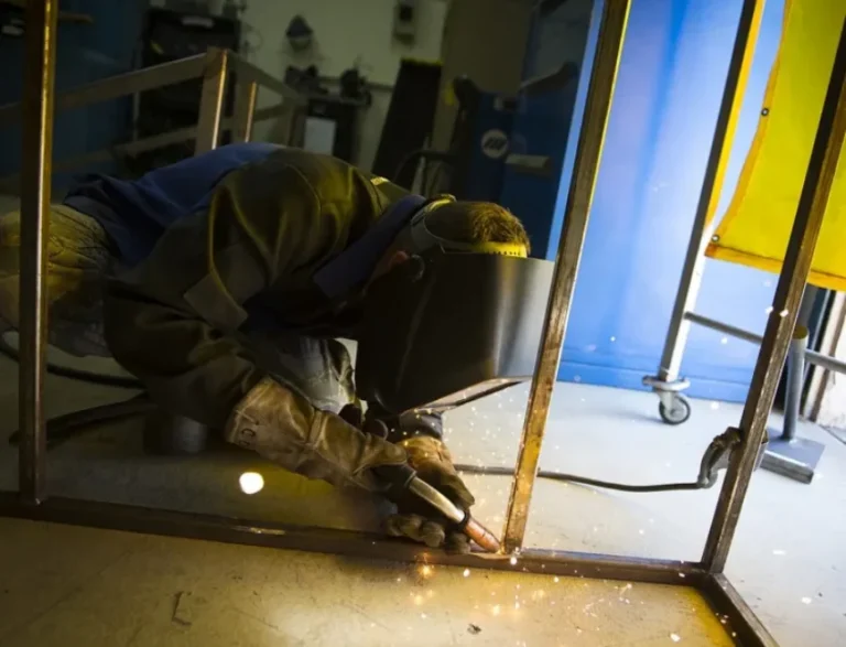Un chaudronnier-soudeur au travail sur une pièce métallique, dans un atelier